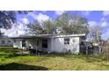 Backyard area with lawn equipment and covered patio, partially fenced at 1814 Elk Ave, Sarasota, FL 34235