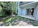 View of outdoor patio surrounded by natural landscaping and a large tree at 2856 Somerset Park Dr # 102, Tampa, FL 33613