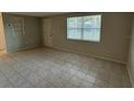 Spacious, empty living room featuring tiled floors and natural light from the window at 4325 Newbury Dr, New Port Richey, FL 34652