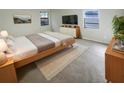Modern bedroom with neutral color tones, a large window, and a comfortable queen-sized bed at 1038 Rolling Oaks Ave, Tarpon Springs, FL 34689