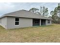 Rear view of a house showcasing a covered patio and spacious backyard at 13009 Parade Ave, Weeki Wachee, FL 34614