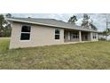 Home's back features a covered patio and grassy backyard at 5356 Frost Rd, Spring Hill, FL 34606