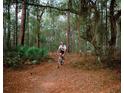 Person mountain biking on a wooded trail at 13233 Gulf Bay Ln, Spring Hill, FL 34609