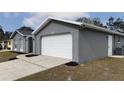 Gray house with white garage door and landscaping at 12117 Topaz St, Spring Hill, FL 34608