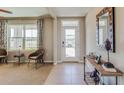 Inviting foyer featuring neutral tones, tile flooring, and an artistic mirror above a wooden console table at 7725 Rome Ln, Brooksville, FL 34613