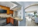 Open-concept kitchen view to living room with granite counters, stainless steel appliances, and wood cabinets at 6372 Palma Del Mar S Blvd # Apt 307, St Petersburg, FL 33715
