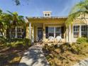 Front view of a yellow house with a porch and white chairs at 5516 Luminar Pointe Ln, Apollo Beach, FL 33572