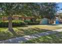 Brick house with a green garage door and a large tree in front at 1813 Laurel Oak Dr, Valrico, FL 33596