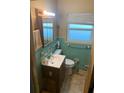 Small bathroom with teal tile and vanity at 1073 Putnam Dr, Sarasota, FL 34234