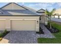 Tan house with gray roof, two-car garage, and paved driveway at 18053 Cherished Loop, Bradenton, FL 34211