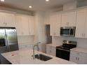 White shaker cabinets, stainless steel appliances, and a large quartz island at 310 Via Anina Dr, Sarasota, FL 34243