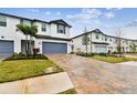 Modern townhome community with landscaped yards and brick paver driveways at 5429 Tripoli Dr, Palmetto, FL 34221