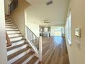 Open living room with hardwood floors and view of the kitchen at 13725 Emerald Fields Dr, Hudson, FL 34667