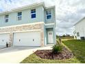 Two-story duplex with light blue exterior and landscaping at 13992 Emerald Fields Dr, Hudson, FL 34667