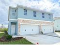 Two-story duplex with attached garages and light blue exterior at 13998 Emerald Fields Dr, Hudson, FL 34667