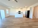 Open concept kitchen with island, stainless steel appliances, and light flooring at 13998 Emerald Fields Dr, Hudson, FL 34667