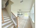 Bright, open staircase with wooden railing leading to an open living area at 14016 Emerald Fields Dr, Hudson, FL 34667