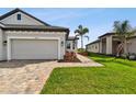 Tan two-car garage with landscaping, and a walkway at 18040 Cherished Loop, Bradenton, FL 34211