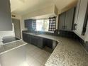 Granite countertops and dark gray cabinets in this updated kitchen at 2529 Ednor St, Port Charlotte, FL 33952