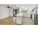 Modern white kitchen with stainless steel appliances and island at 6628 Keystone Dr, Sarasota, FL 34231