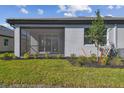 Screened in patio area with landscaped yard and a newly planted tree at 18024 Cherished Loop, Bradenton, FL 34211