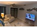Cozy living room with neutral tones, a ceiling fan, and entertainment options at 246 176Th E Ave, Redington Shores, FL 33708