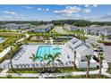 Aerial view showcasing a sparkling pool, tennis court, and playground amenities in a Gathering-friendly community at 7526 Backlight Ln, Sarasota, FL 34240