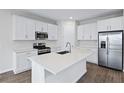 Modern kitchen with white cabinets, island, and stainless steel appliances at 5943 Jensen View Ave, Apollo Beach, FL 33572
