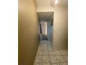 Long hallway with light brown walls and tiled floor at 5501 Pokeweed Ct # D, Tampa, FL 33617