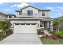 Two-story house with light beige siding and a two car garage at 5917 Jensen View Ave, Apollo Beach, FL 33572