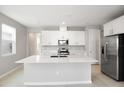 Modern kitchen with white cabinets, stainless steel appliances, and an island at 5917 Jensen View Ave, Apollo Beach, FL 33572