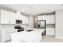 Modern kitchen with white cabinets, stainless steel appliances, and an island at 5917 Jensen View Ave, Apollo Beach, FL 33572