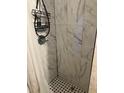 Clean shower with white marble tile and a black shower caddy at 109 W Floribraska Ave, Tampa, FL 33603