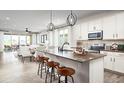 Open concept kitchen island with white cabinets, stainless steel appliances, and spacious layout at 9049 Players Dr, Weeki Wachee, FL 34613