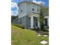 Two-story townhome with gray siding, white trim, and a dark brown door at 5046 Avalon Park Blvd, Wesley Chapel, FL 33545