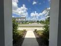 View from porch showing a paved walkway, landscaping, and neighboring homes at 5046 Avalon Park Blvd, Wesley Chapel, FL 33545