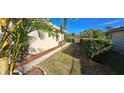 Landscaped backyard with a side walkway and fence at 13 Pebble Beach Rd, Rotonda West, FL 33947