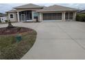 Two-story house with a large driveway and landscaping at 13 Pebble Beach Rd, Rotonda West, FL 33947