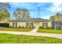 Inviting single-story home with black shutters, green paint, and a nicely paved walkway to the front door at 8600 W Knights Griffin Rd, Plant City, FL 33565