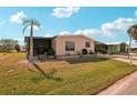 Single-story home with a green lawn, tall palm tree, and covered parking at 313 Mariner Dr, North Port, FL 34287