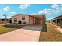 Charming single-story home with well-manicured lawn and covered carport and driveway at 313 Mariner Dr, North Port, FL 34287