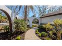 Landscaped walkway leading to a charming house entrance at 4907 Parson Brown Ln, Palm Harbor, FL 34684
