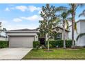 Inviting single-Gathering home boasts manicured lawn, a two-car garage, and enhanced curb appeal at 16605 Myrtle Sand Dr, Wimauma, FL 33598