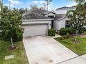 Well-maintained one story home featuring a spacious driveway and manicured lawn and landscaping at 16605 Myrtle Sand Dr, Wimauma, FL 33598