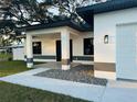 Inviting front porch with stone details and modern lighting that enhance the home's curb appeal at 302 E Clay Ave, Brandon, FL 33510