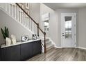 Bright foyer with a glass panel front door, wood-look tile, and a decorative stair rail at 5916 Jensen View Ave, Apollo Beach, FL 33572