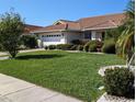 Single story home with a large green lawn and mature landscaping at 721 Plumbrook Rd, Sun City Center, FL 33573