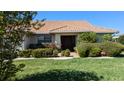 Single-story home with tile roof, landscaping, and a double door entry at 721 Plumbrook Rd, Sun City Center, FL 33573