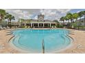 Community pool with lounge chairs and clubhouse at 2220 Kings Palace Dr, Riverview, FL 33578