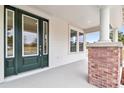 Front porch with brick columns and a dark green front door at 2607 N 21St St, Tampa, FL 33605